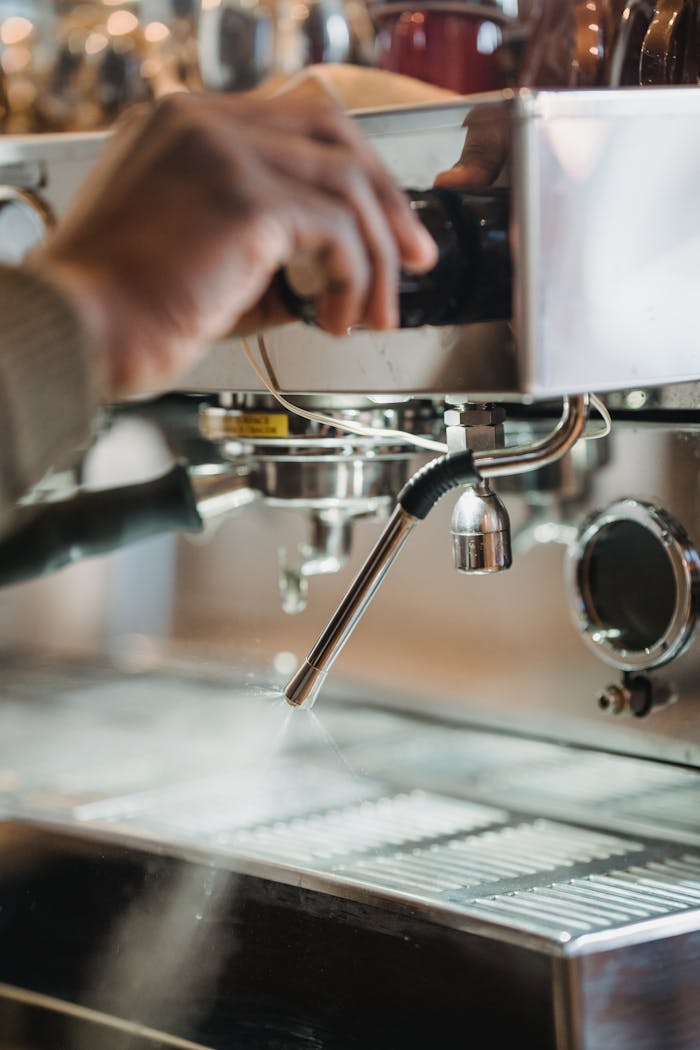Un coffee-truck pas comme les autres... Close-up of a barista operating an espresso machine in a cozy café environment.