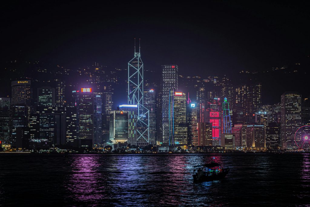 Stunning view of Hong Kong skyline with neon lights reflecting on water at night.